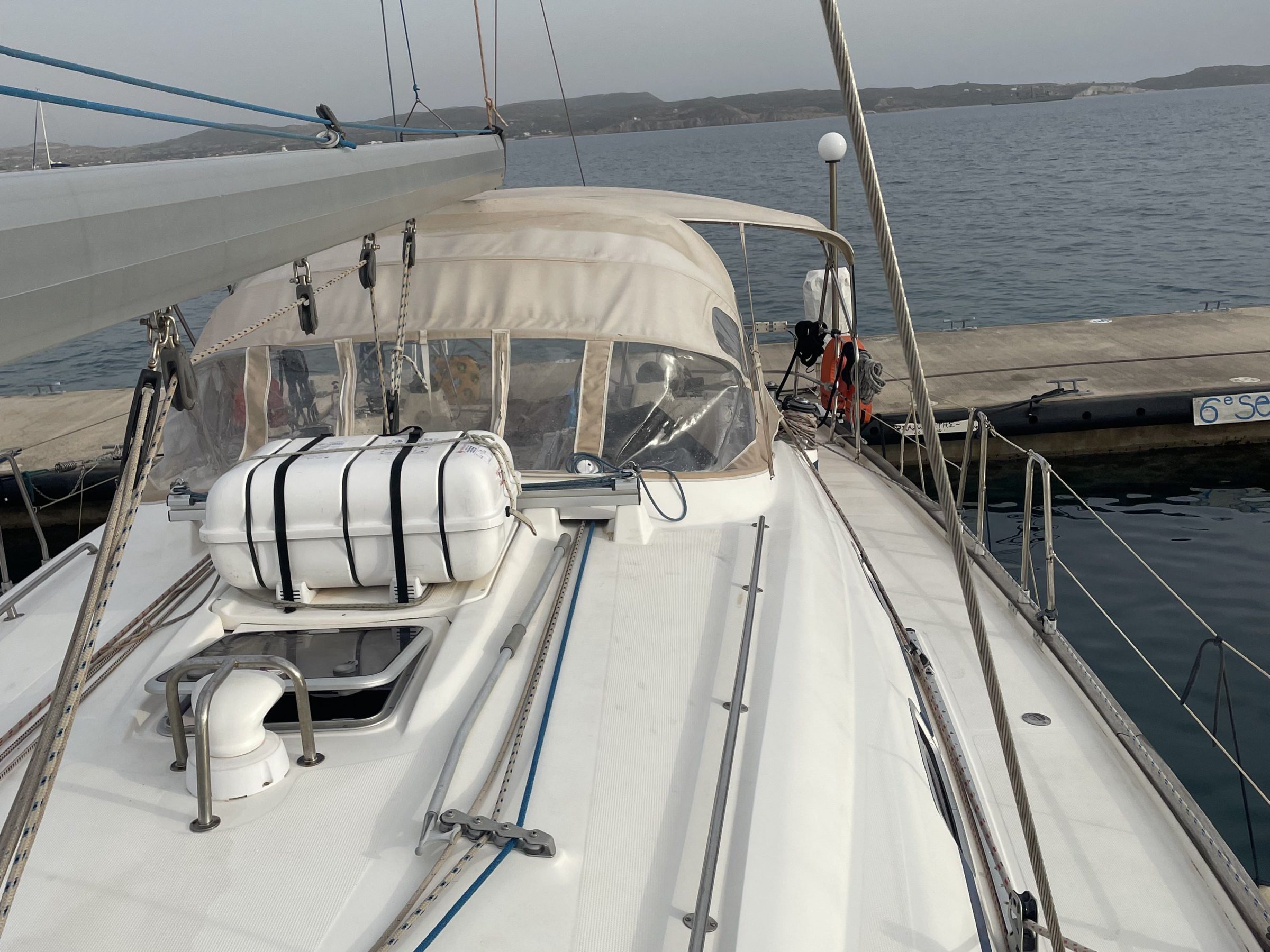 View from a yacht's deck toward the horizon, docked at a marina.
