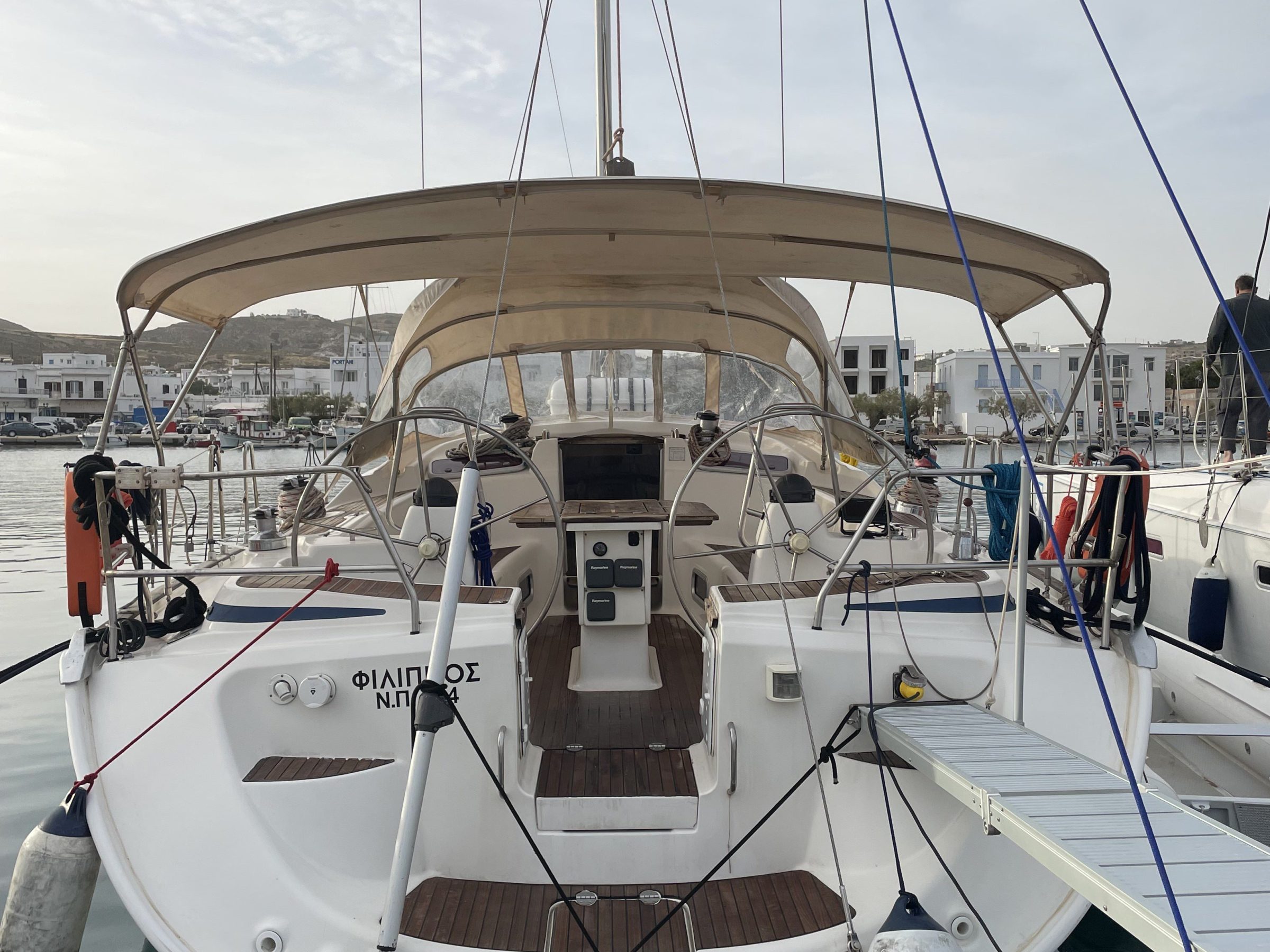 Rear view of a docked sailboat with open cockpit and blue sky.